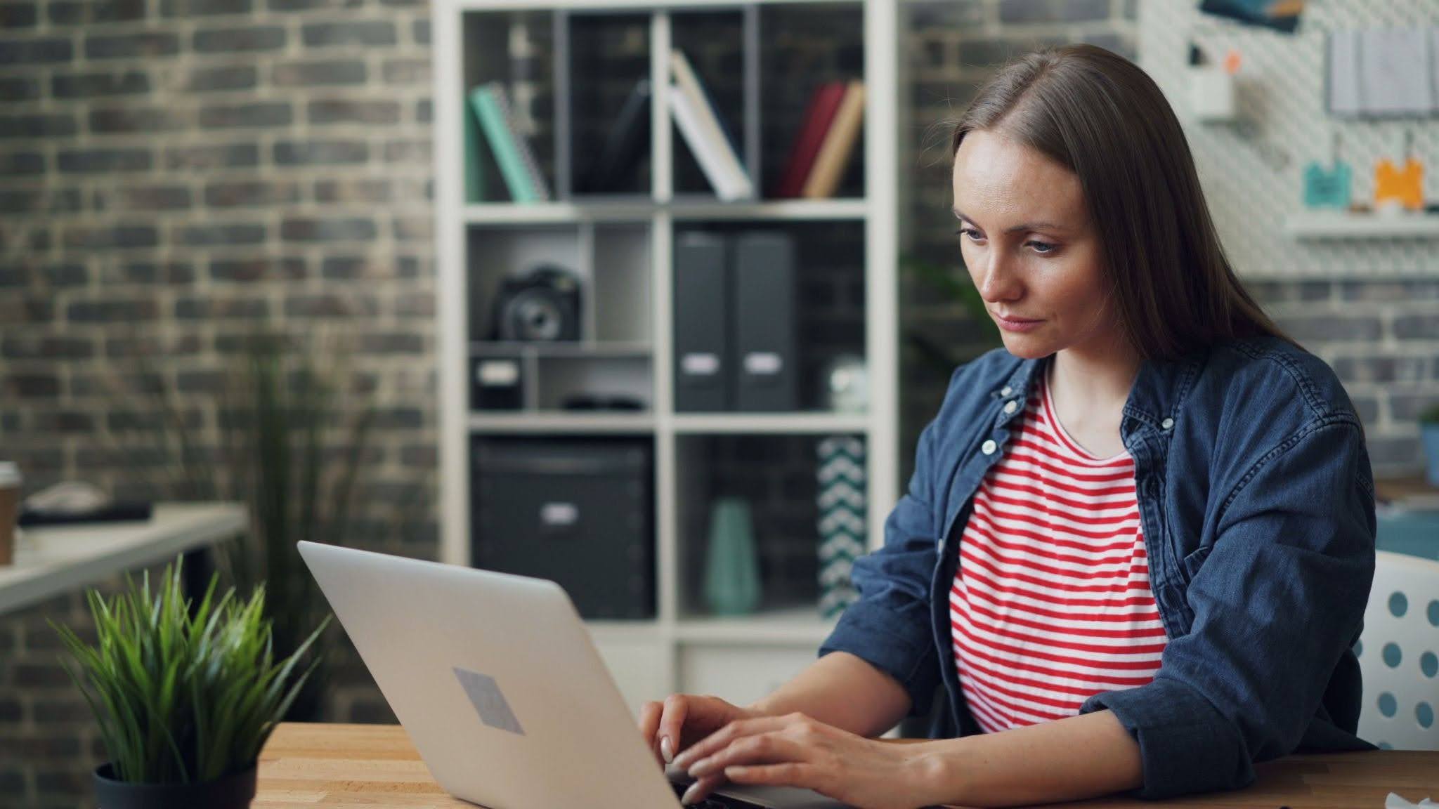 A woman researching surrogacy agencies on her laptop